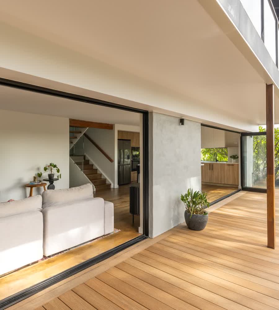Living room opening through sliding doors to a timber deck