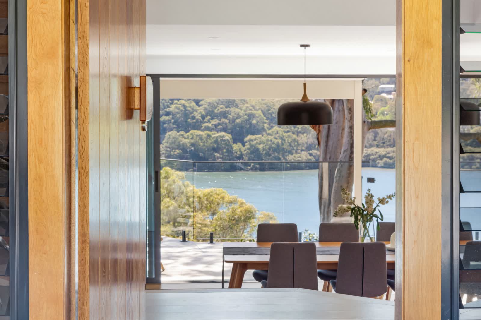 Dining room looking out to the water through timber framed doors