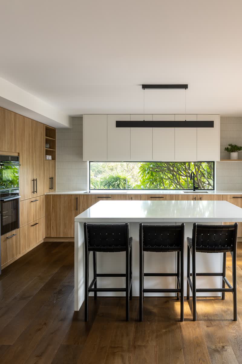 Open-plan kitchen with bifold doors open to the deck