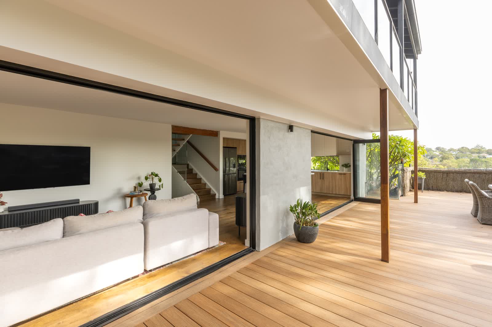 Living room opening through sliding doors to a timber deck