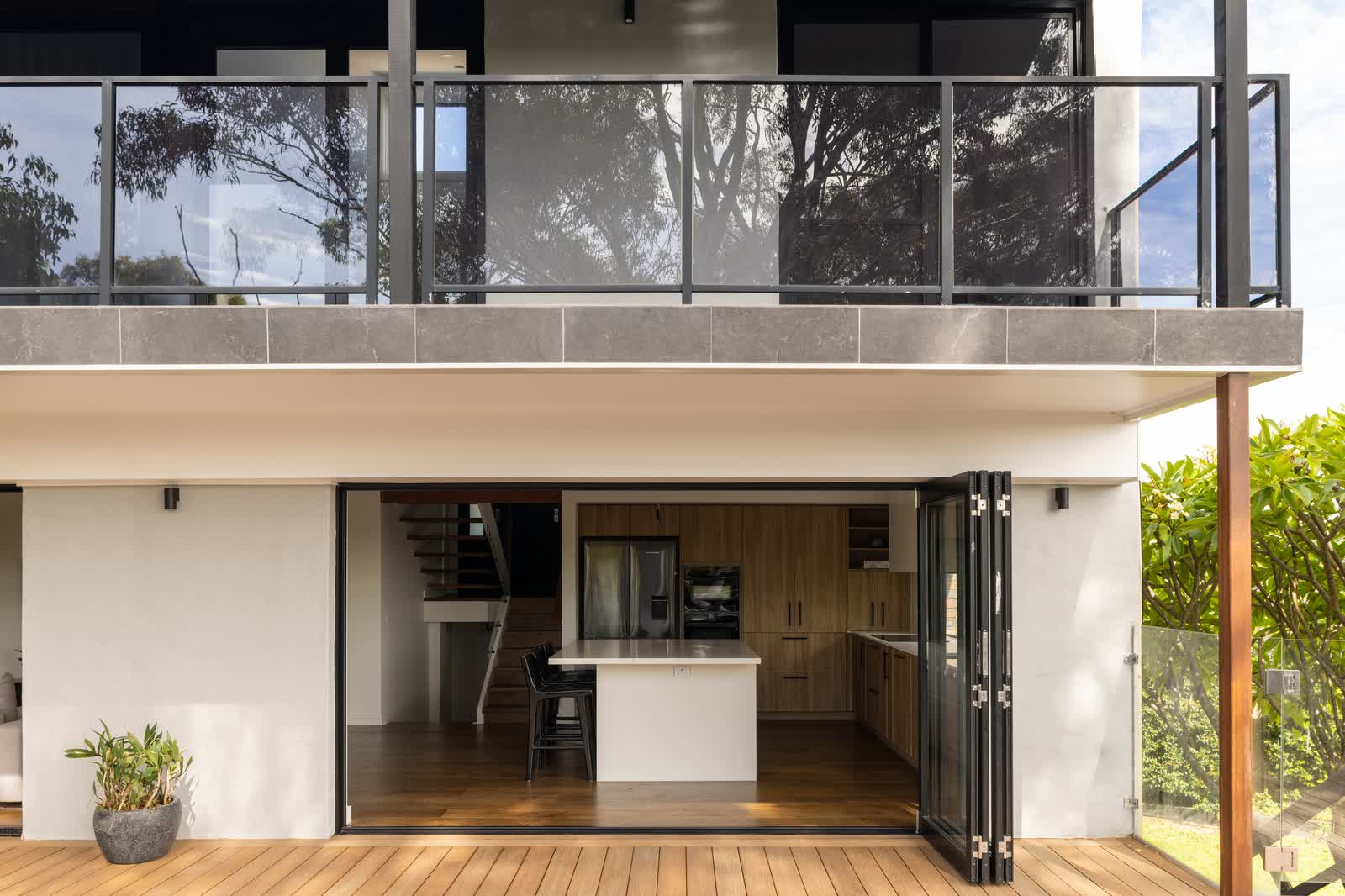 Rear of the home with an upper balcony over open bifolds