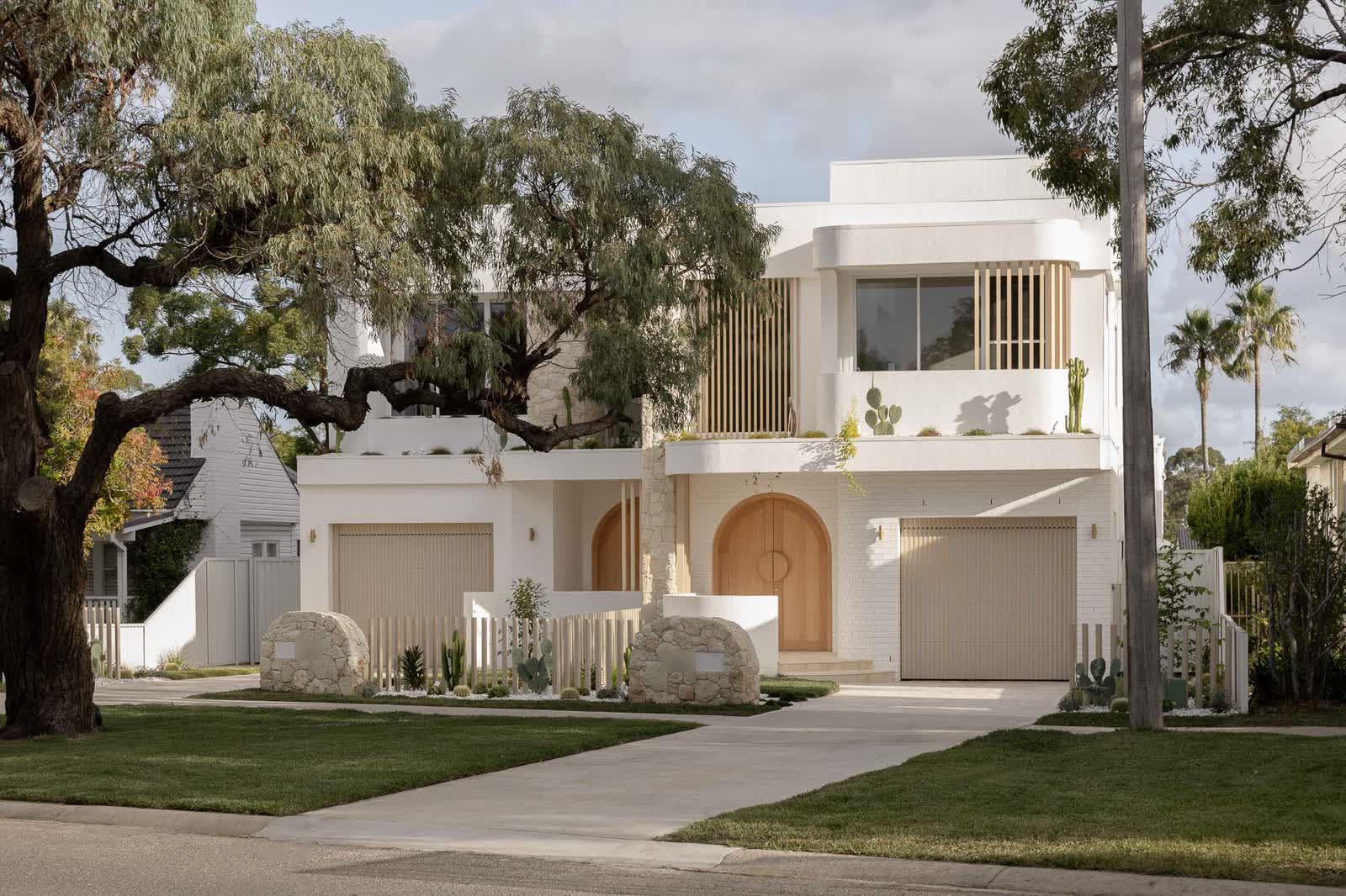 Street front of the white render and sandstone duplex