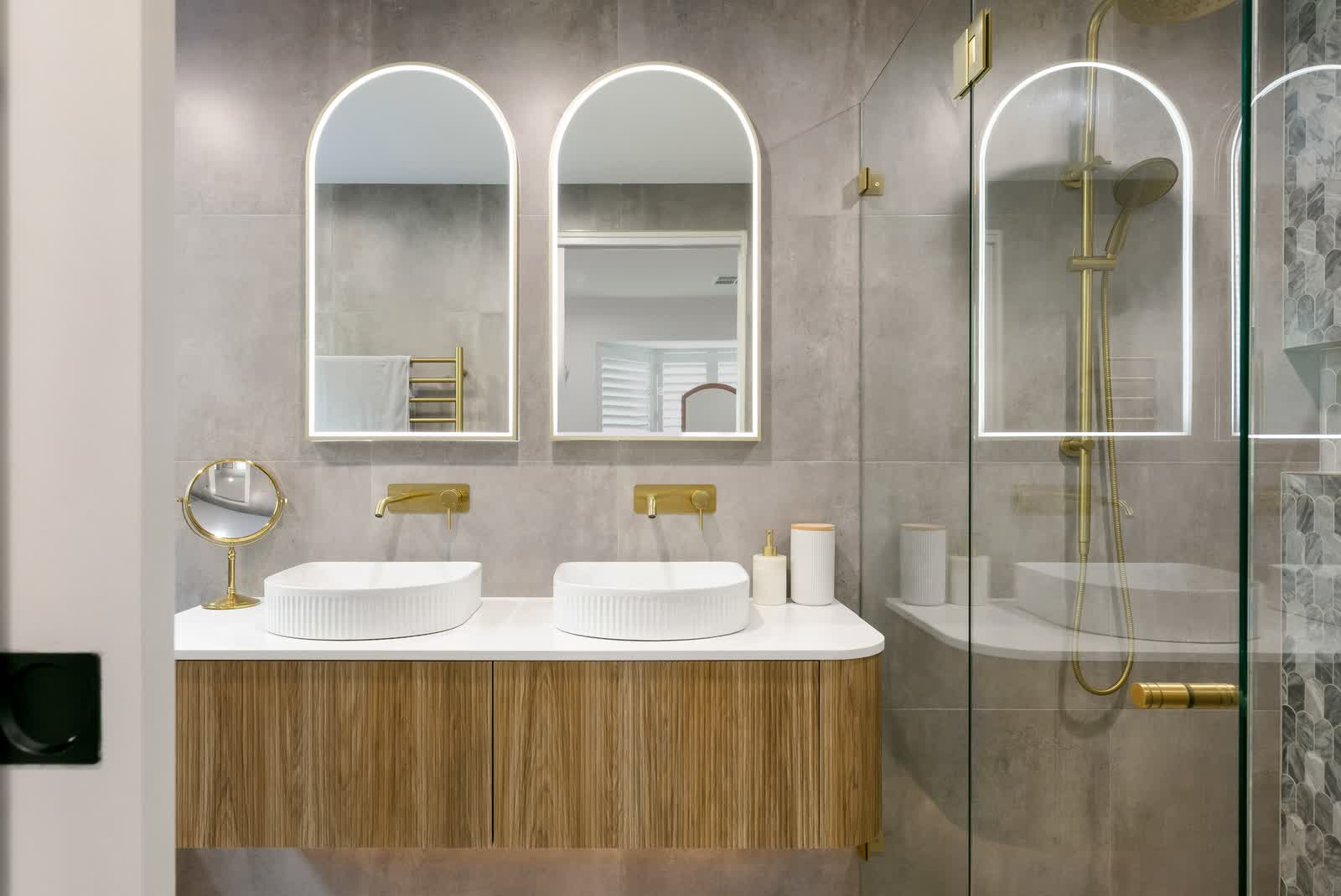Bathroom with arched mirrors and brass tapware