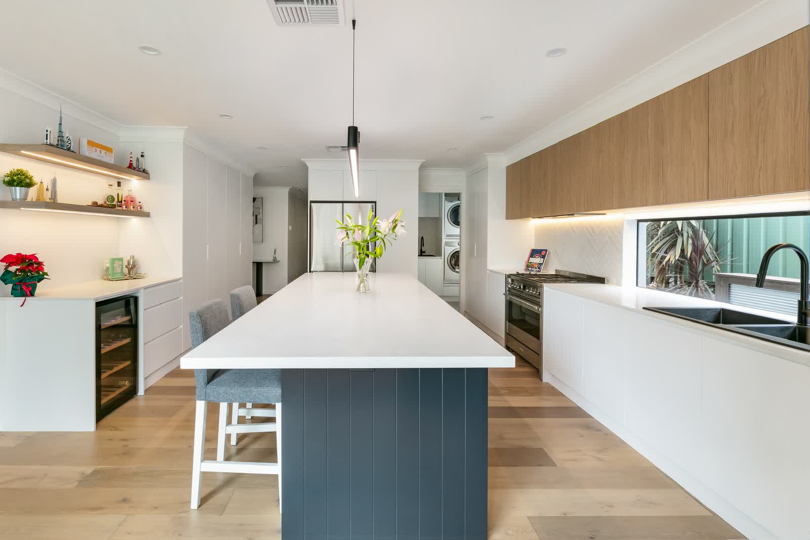 Kitchen with a long island and window splashback