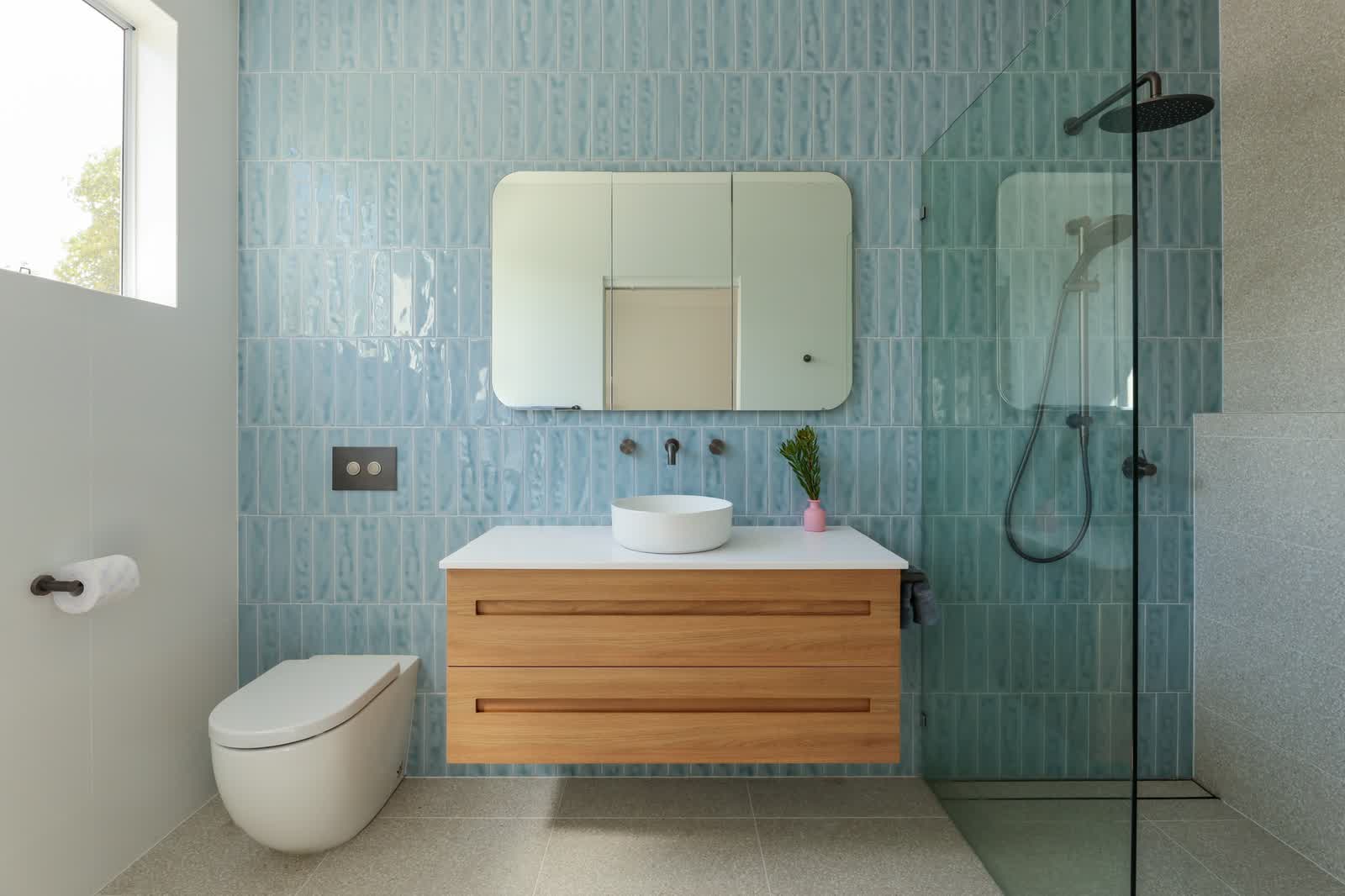 Bathroom with blue tiles and a timber vanity